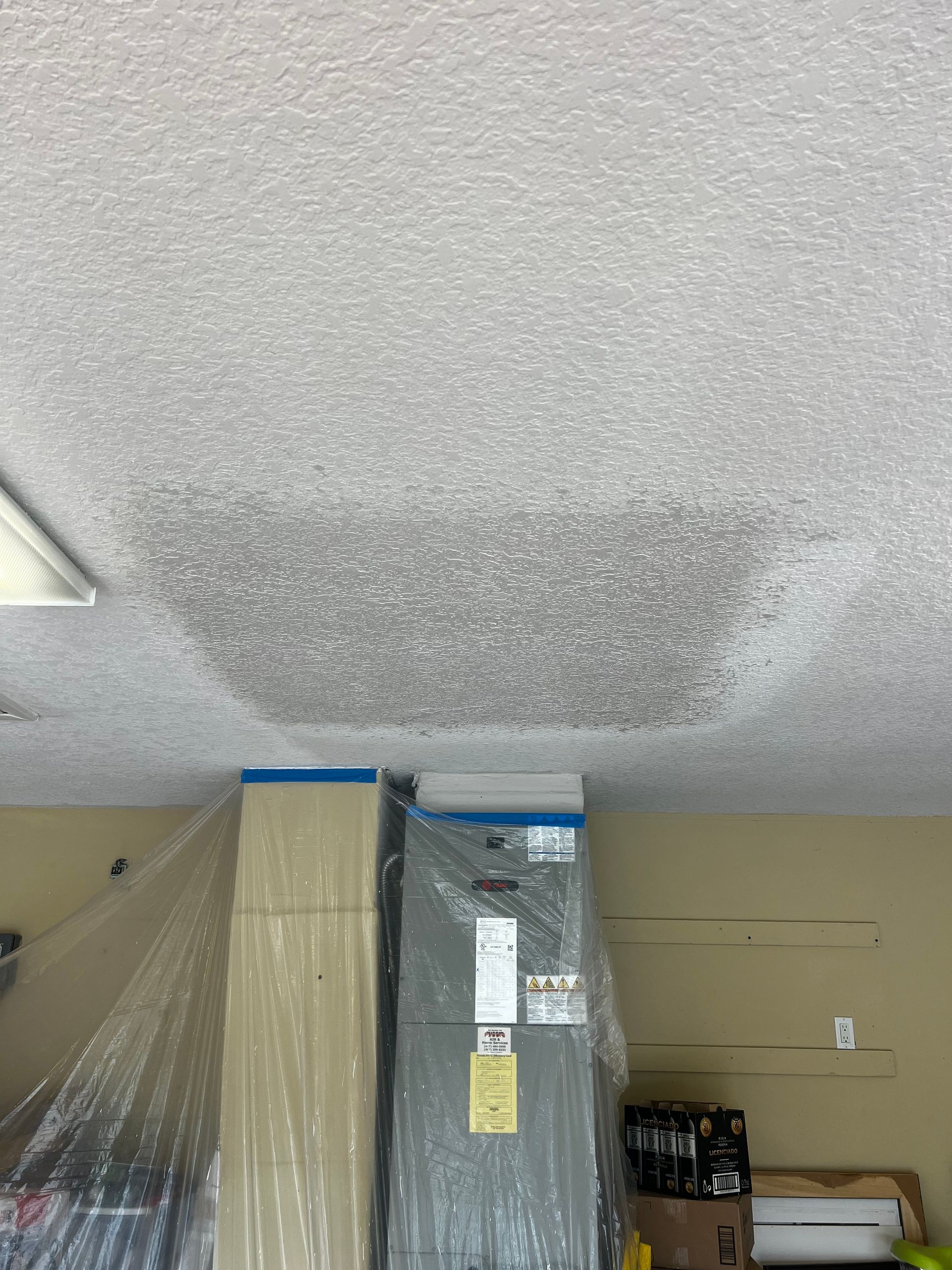 A ceiling is being painted in a garage.