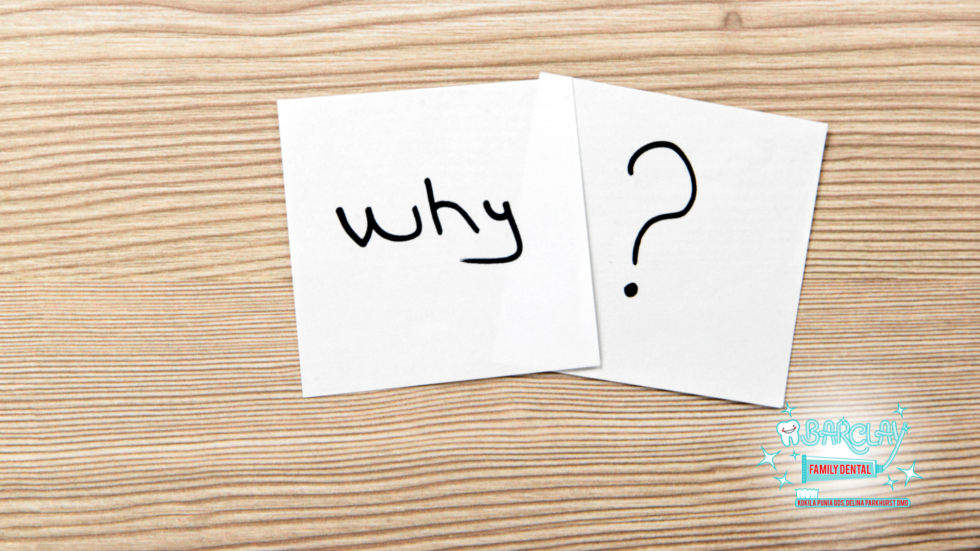 Two sticky notes on a wooden table that say why and a question mark