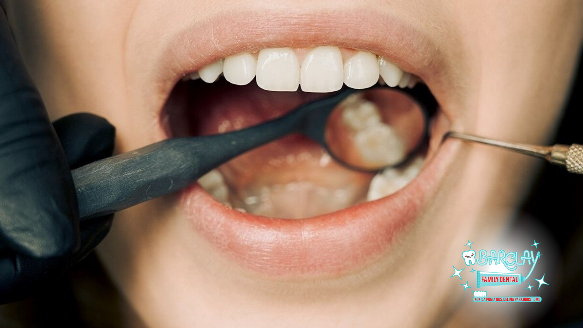 A woman is getting her teeth examined by a dentist.