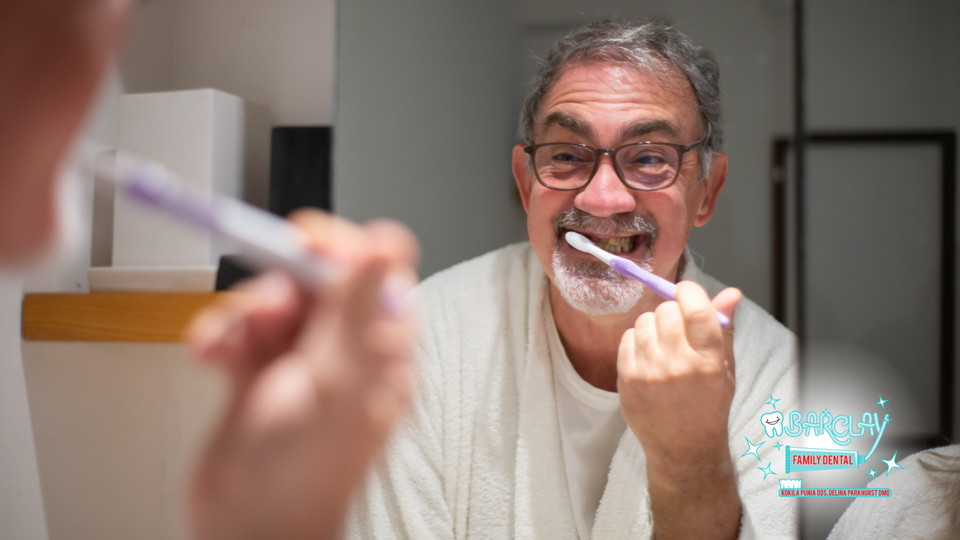 An older man is brushing his teeth in front of a mirror.