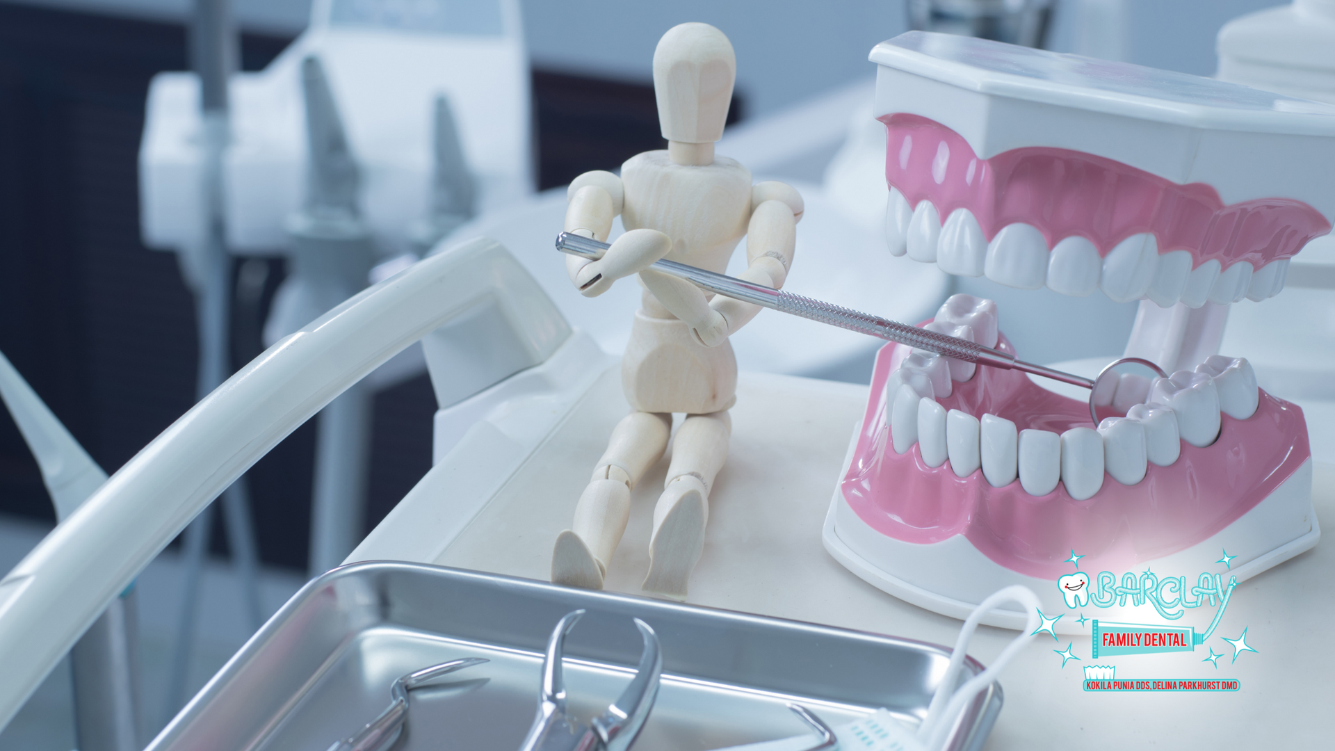 A mannequin is sitting next to a model of teeth in a dental office.