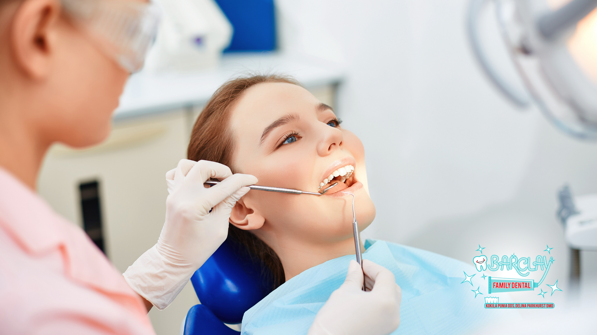 A woman is sitting in a dental chair getting her teeth examined by a dentist.