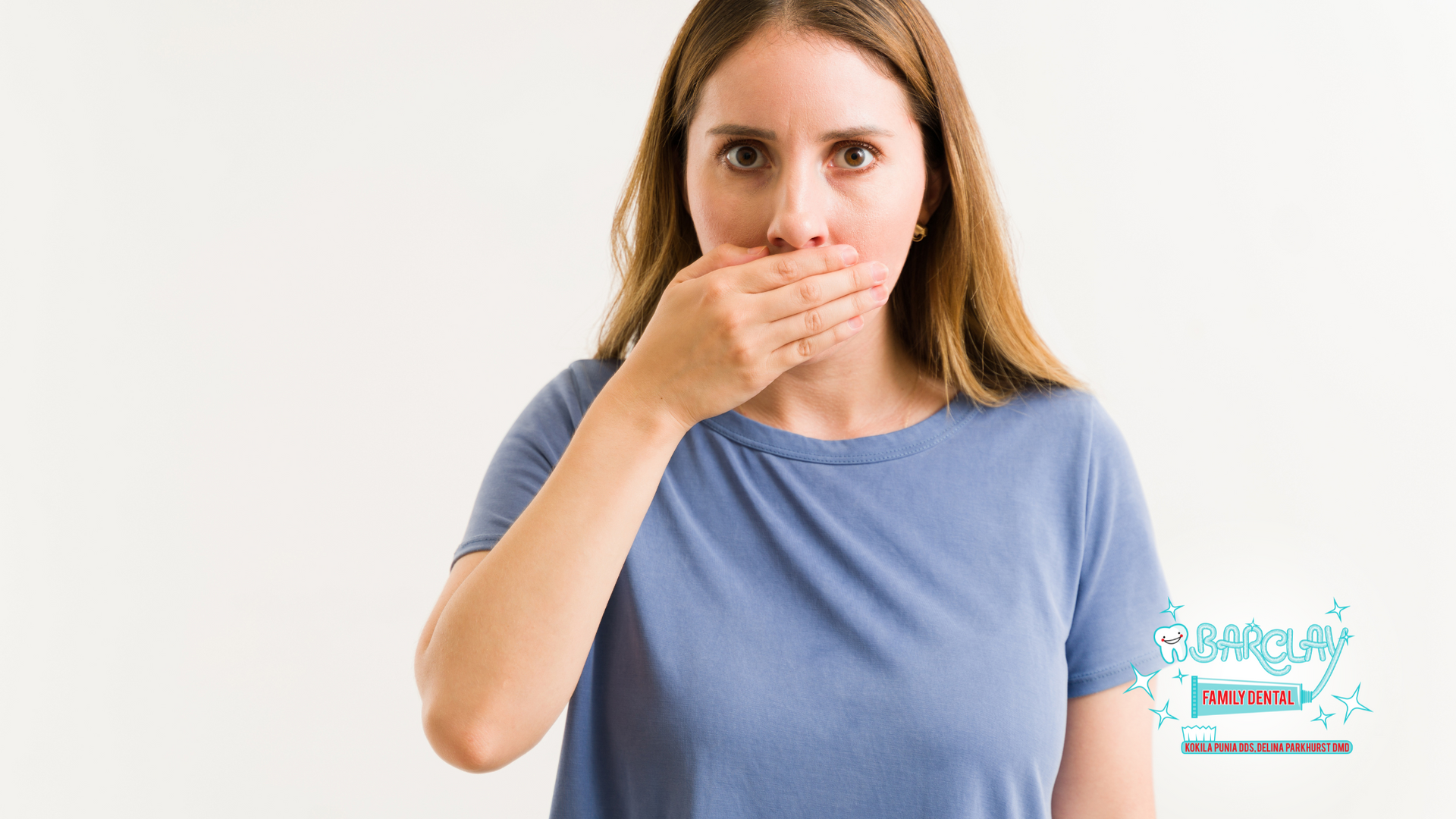 A woman is covering her mouth with her hand.