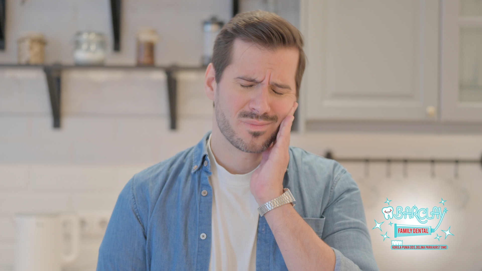 A man is holding his face in pain because he has a toothache.