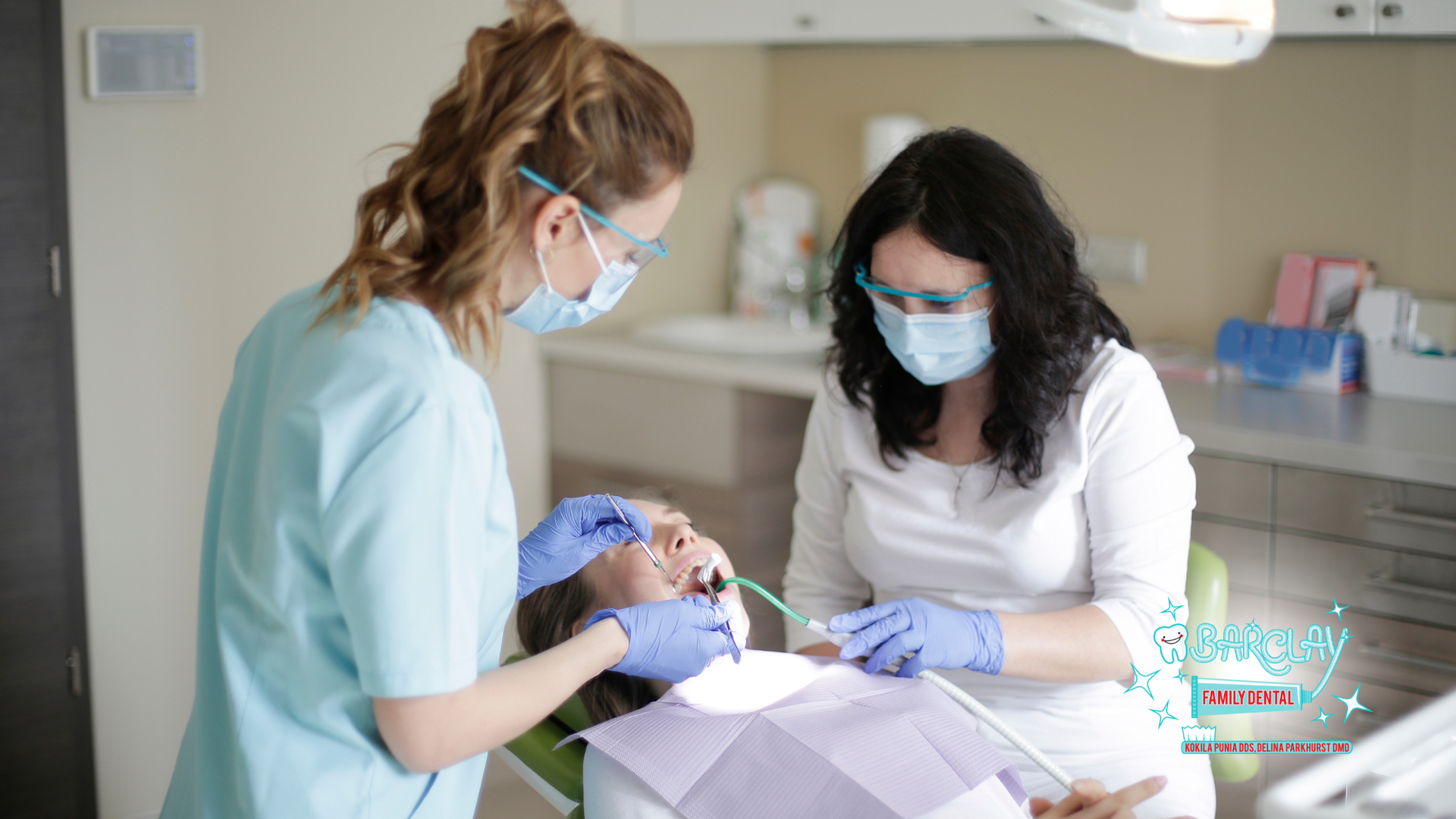 A dentist and a nurse are examining a patient 's teeth in a dental office.