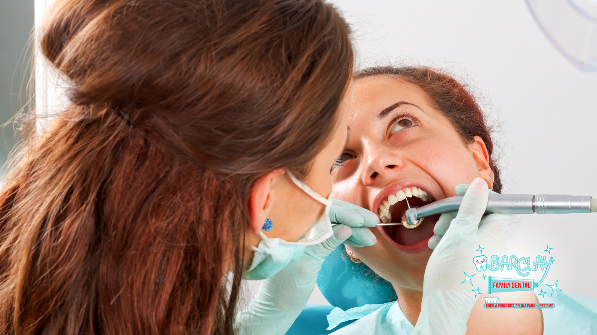 A woman is getting her teeth examined by a dentist.