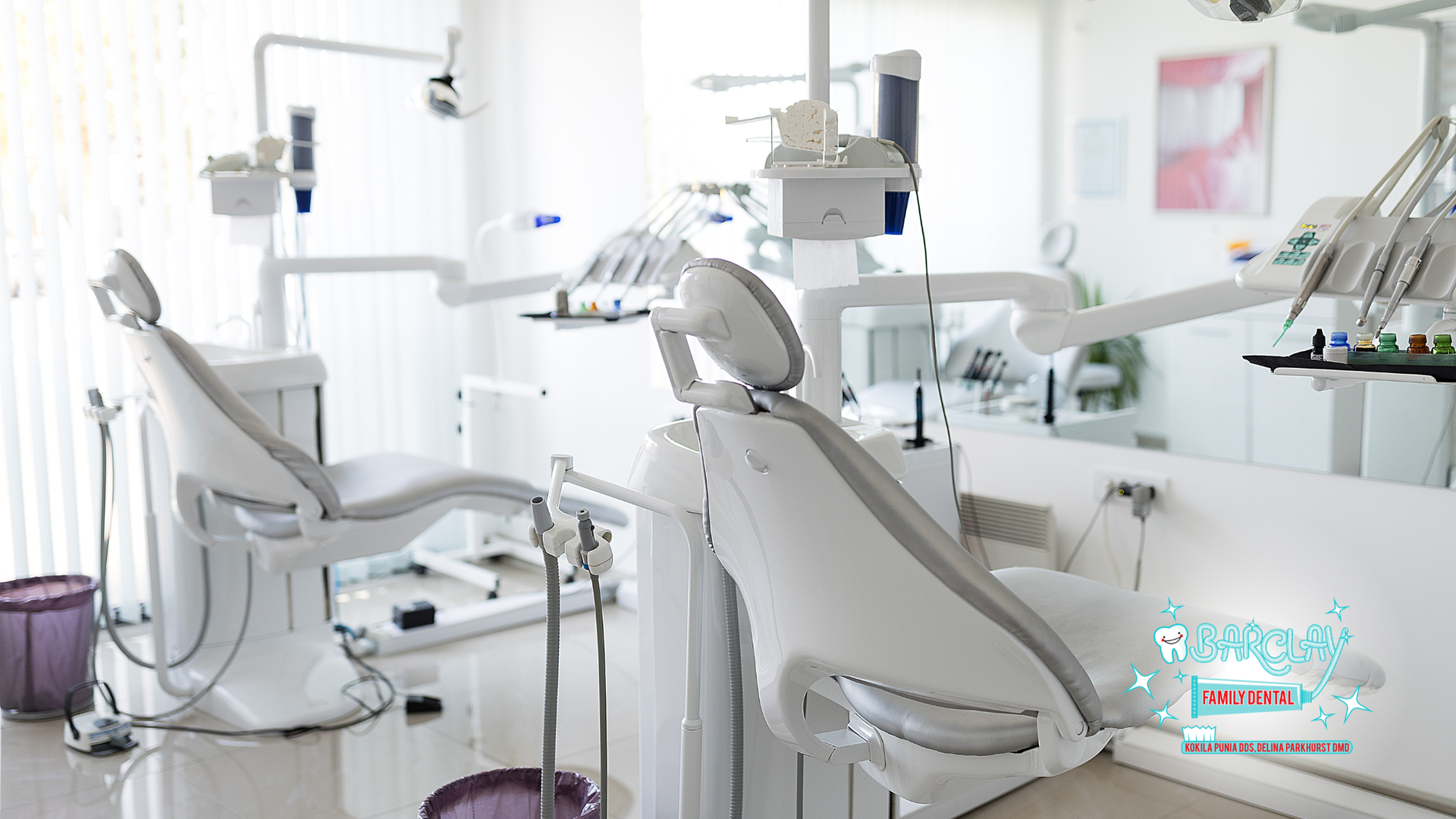 Dental office interior with dental chairs, equipment, and bright lighting.