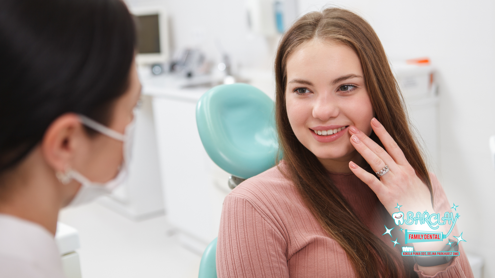 A woman is sitting in a dental chair talking to a dentist.