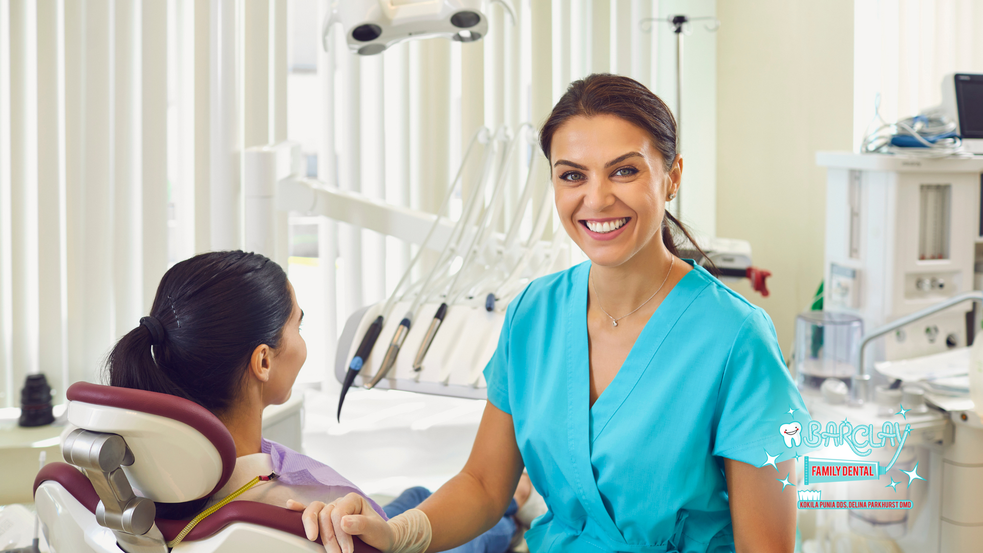 A female dentist is talking to a patient in a dental chair.