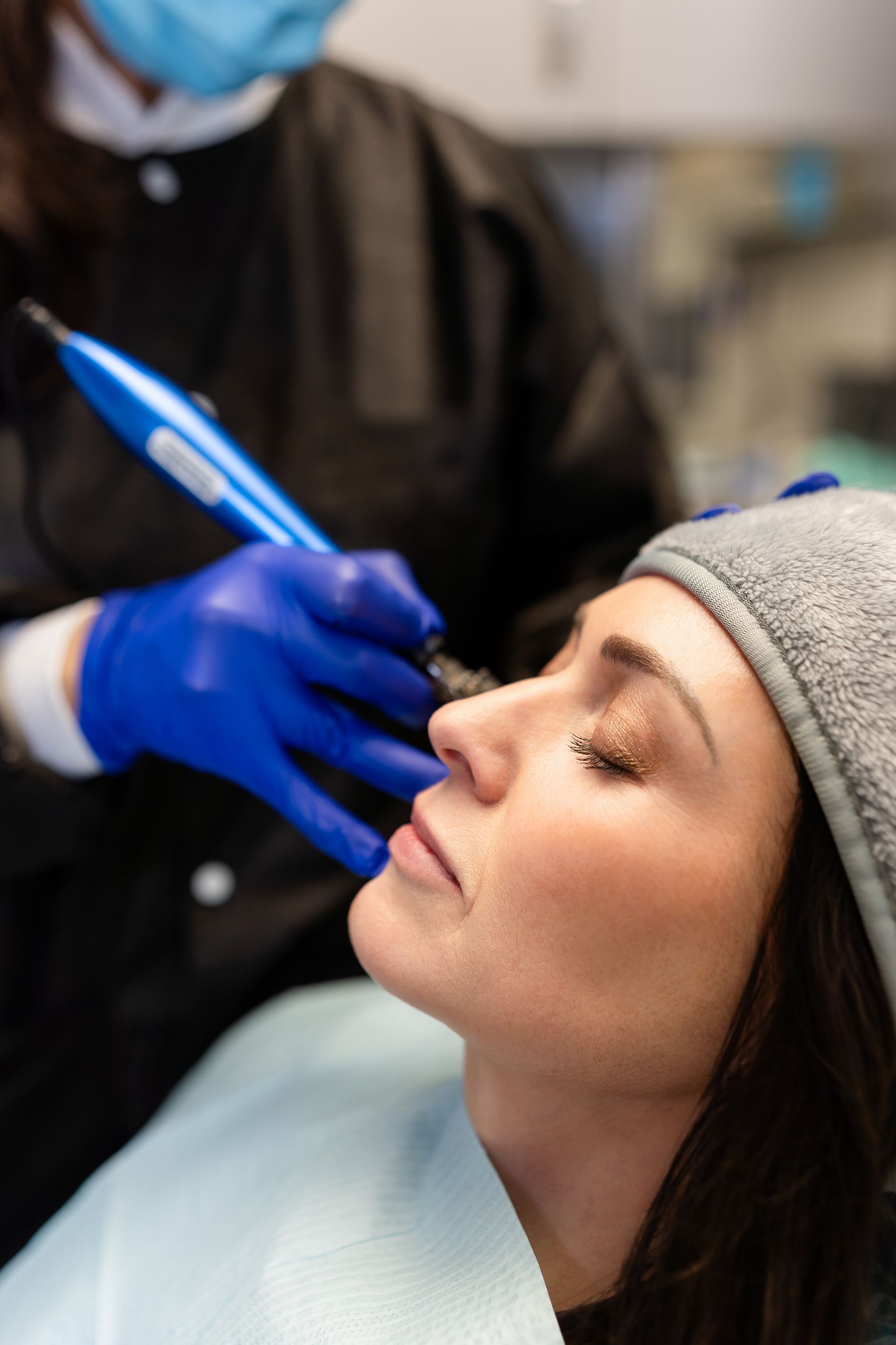 a woman wearing a hat and sweater is smiling in front of a christmas tre | Barclay Family Dental | Best Dentist For Family Dentistry, Dental Implants, and Cosmetic Dentistry in Cherry Hill, NJ