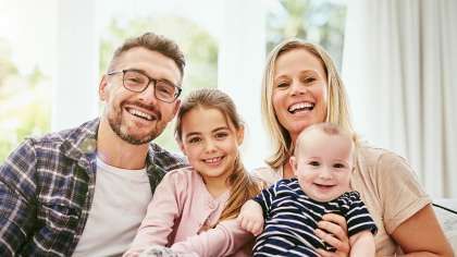 a family is posing for a picture while sitting on a couch | Barclay Family Dental | Best Dentist For Family Dentistry, Dental Implants, and Cosmetic Dentistry in Cherry Hill, NJ