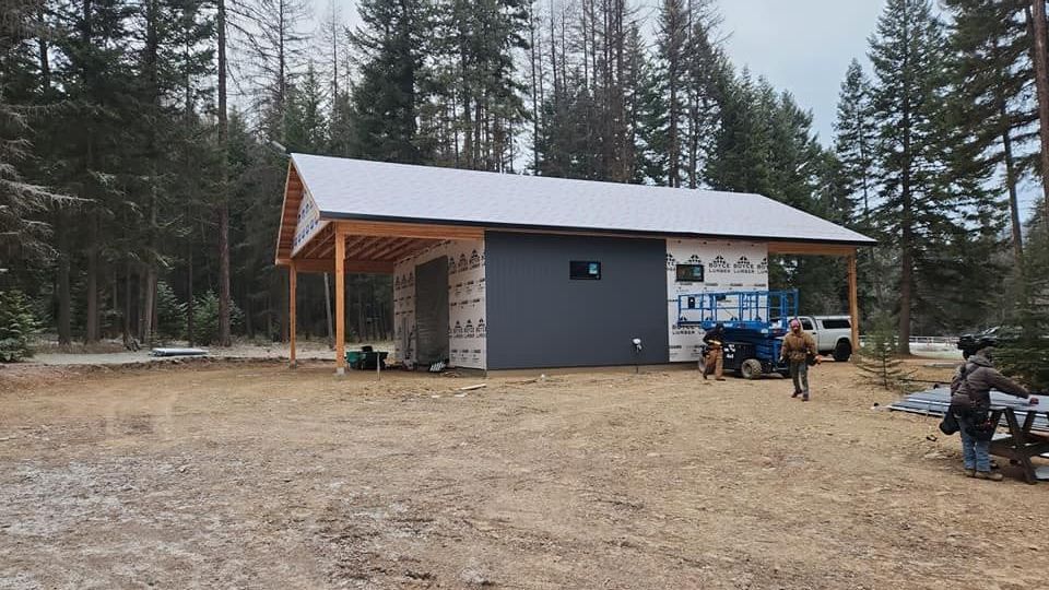 A tractor is parked in front of a building under construction.