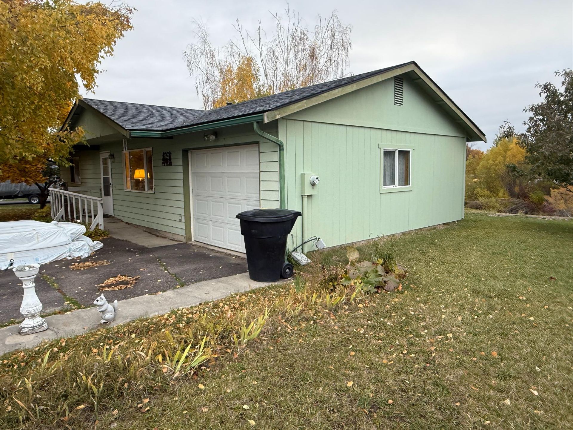 A house with a red tile roof is surrounded by trees and a path leading to it.