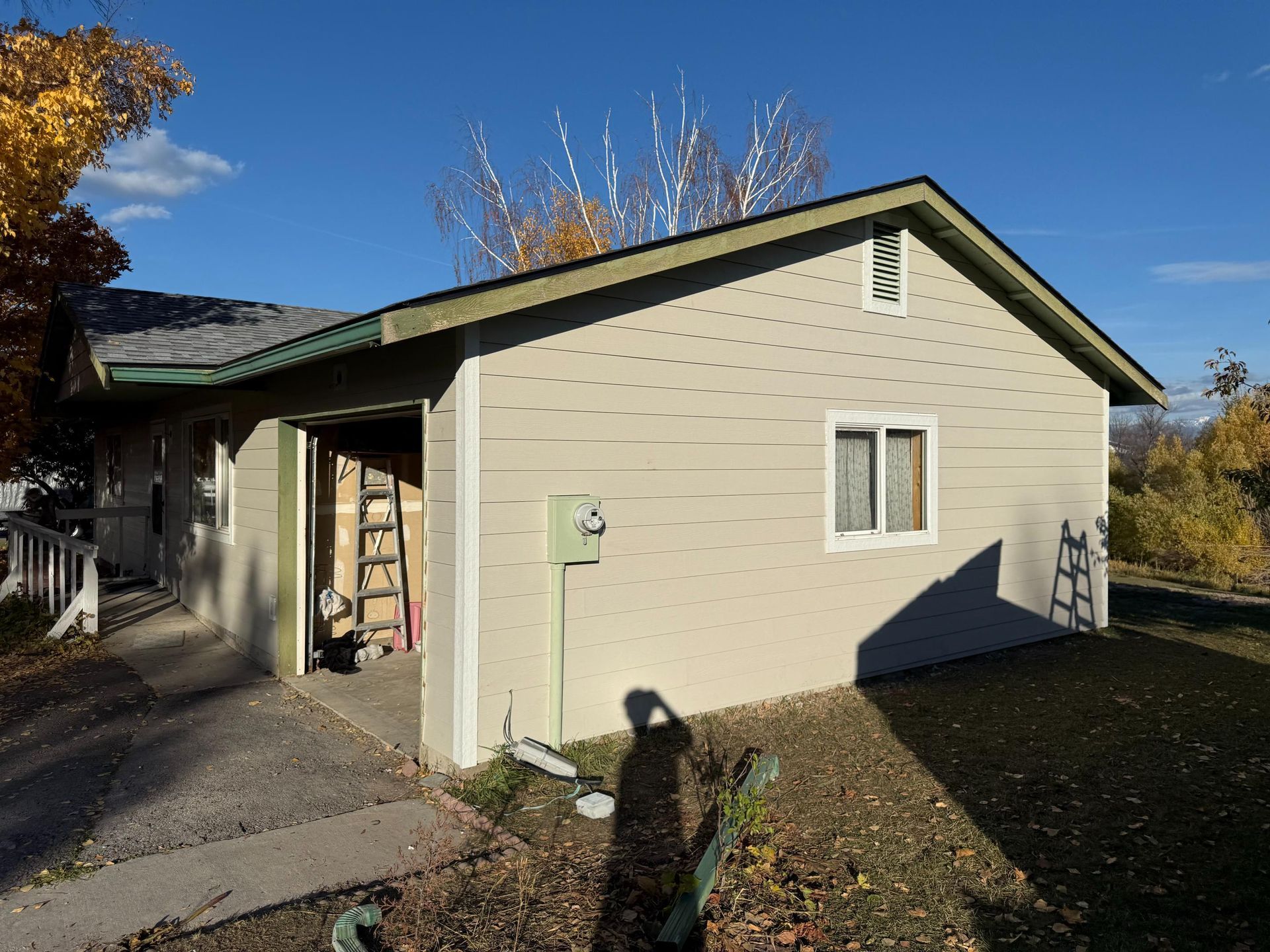 A large house is surrounded by snow and trees