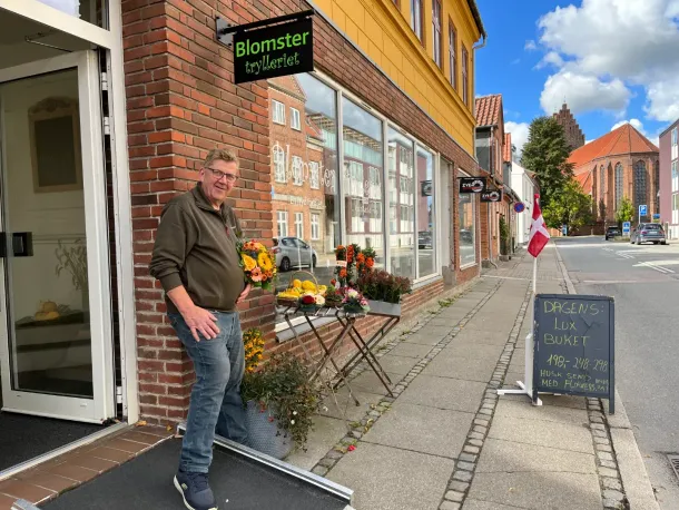 Mand står uden for blomsterbutikken