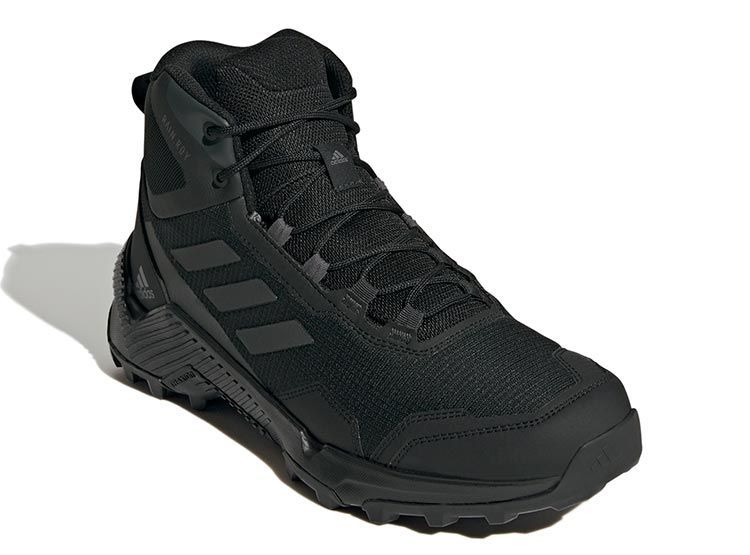 Bota de senderismo Adidas negra con tres rayas en el lateral y suela resistente.