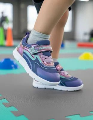 Zapatilla infantil Bubblegummers negra y roja con correa de velcro y suela luminosa.