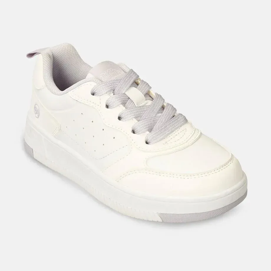 Zapatilla deportiva color crema con cordones y suela grises, sobre fondo blanco.