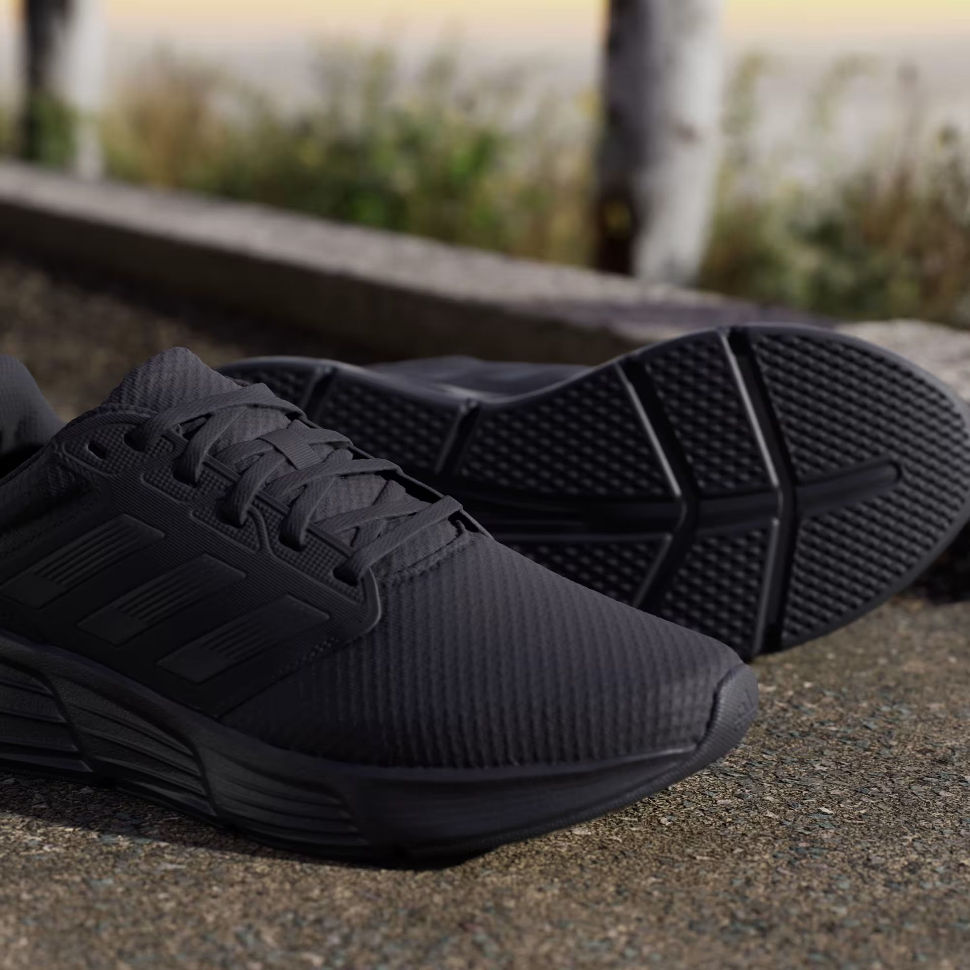 Zapatillas de running Adidas negras sobre fondo blanco.