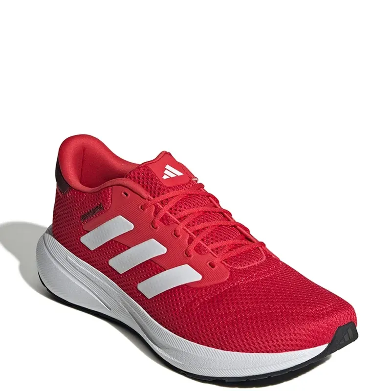 Zapatilla Adidas roja con rayas y suela blancas.