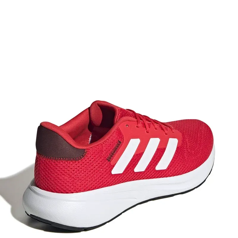 Zapatilla Adidas roja con rayas y suela blancas.