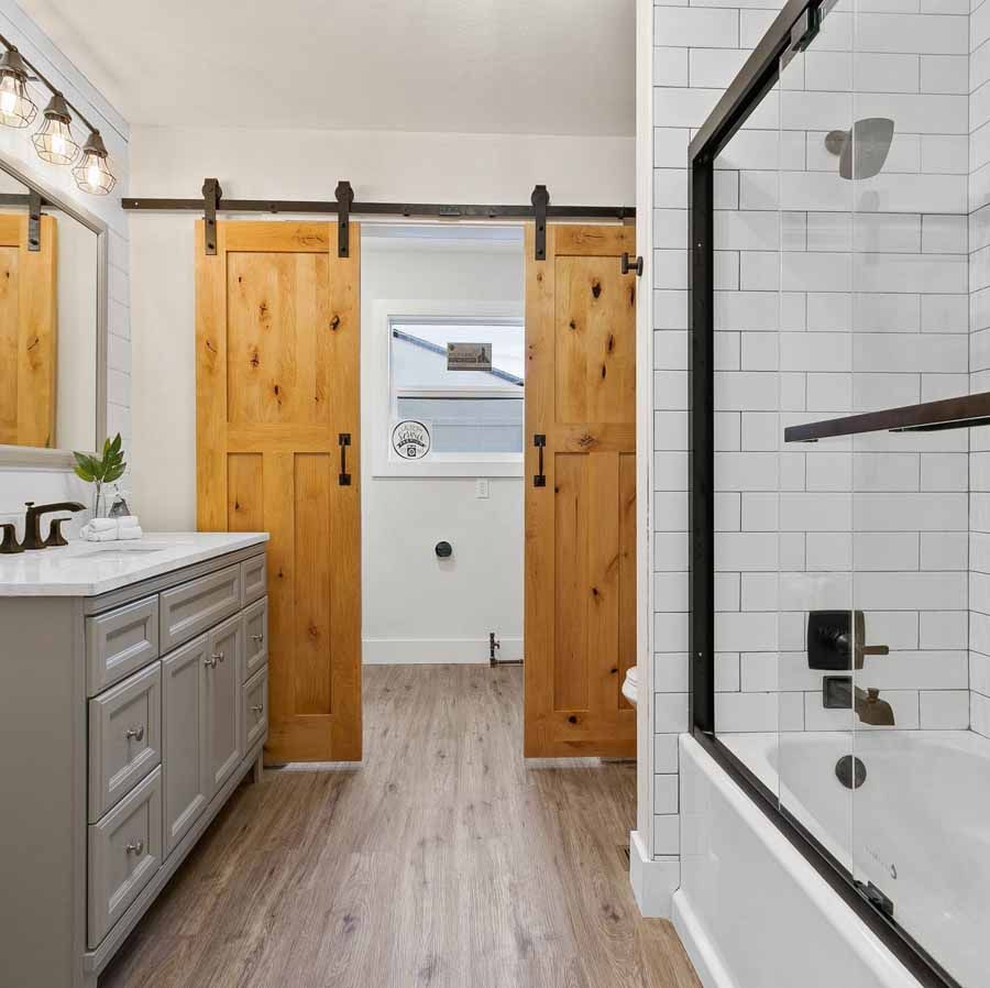 A bathroom with sliding barn doors and a bathtub.