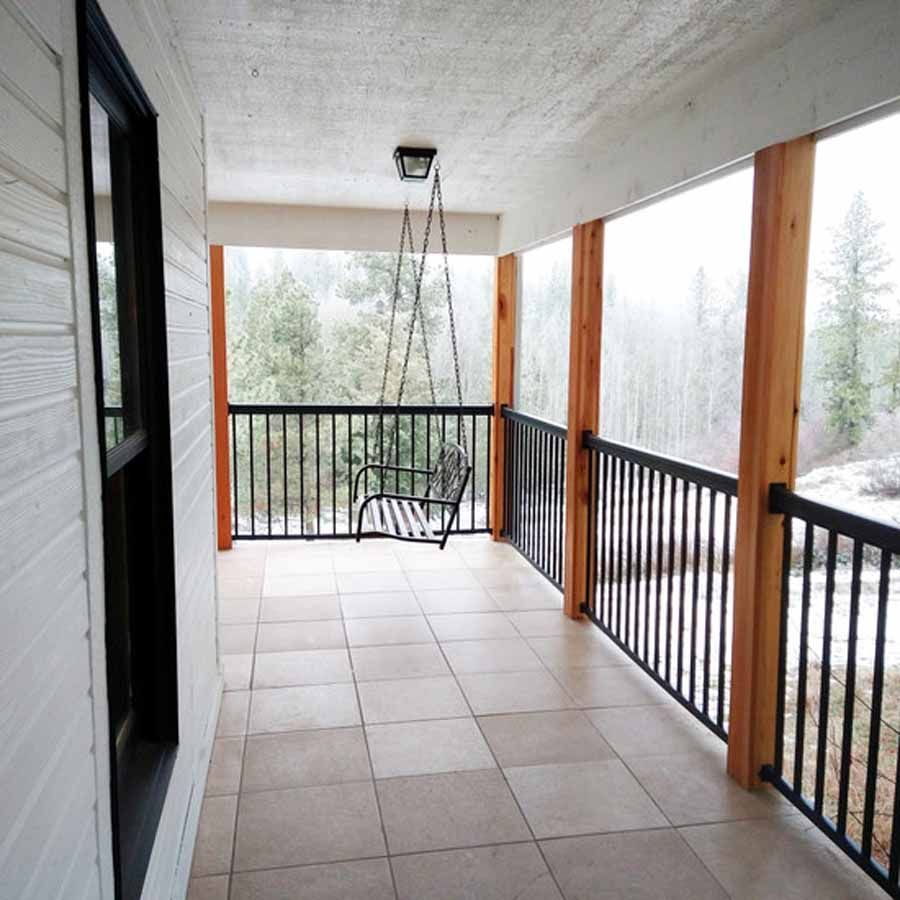 A porch with a swing hanging from the ceiling