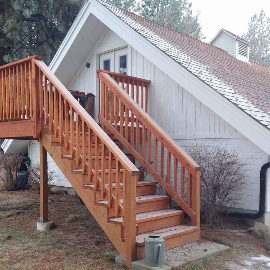 A white house with wooden stairs leading up to it