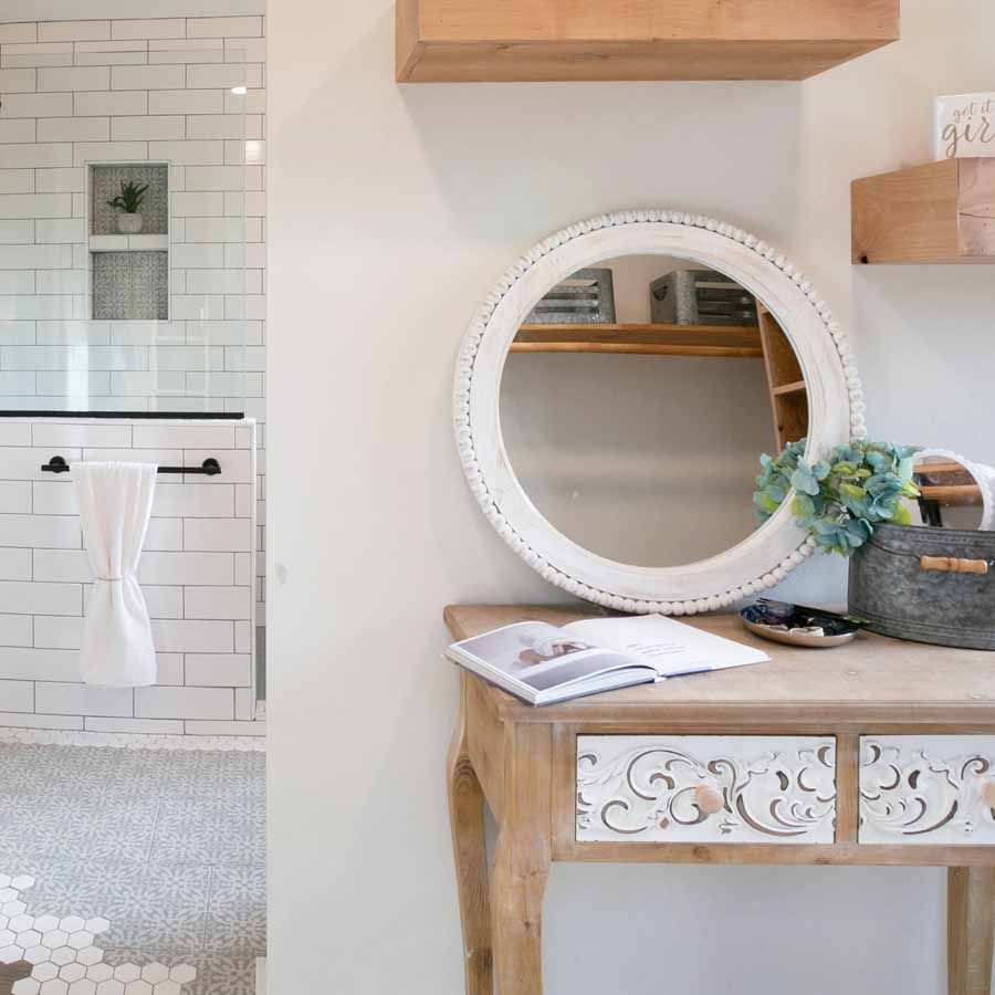 A wooden table with a mirror on top of it in a bathroom.