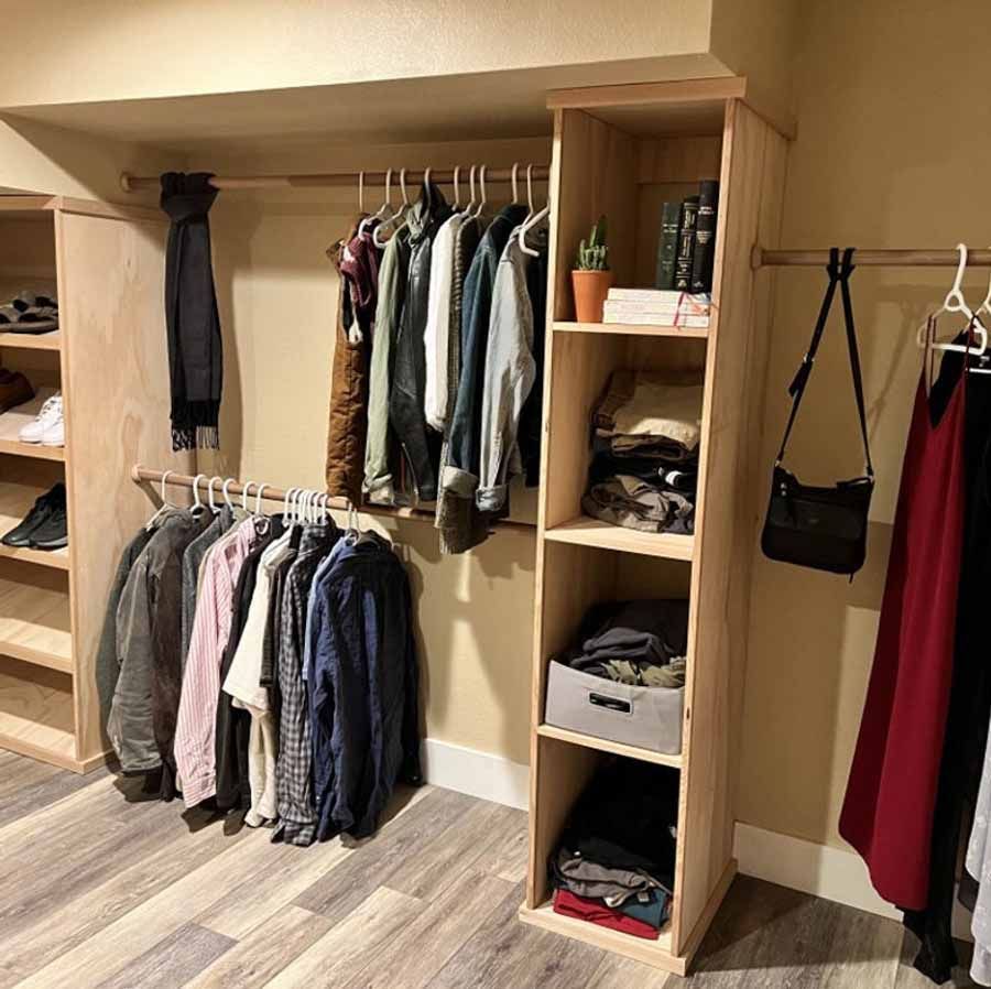 A closet filled with lots of clothes and a purse.