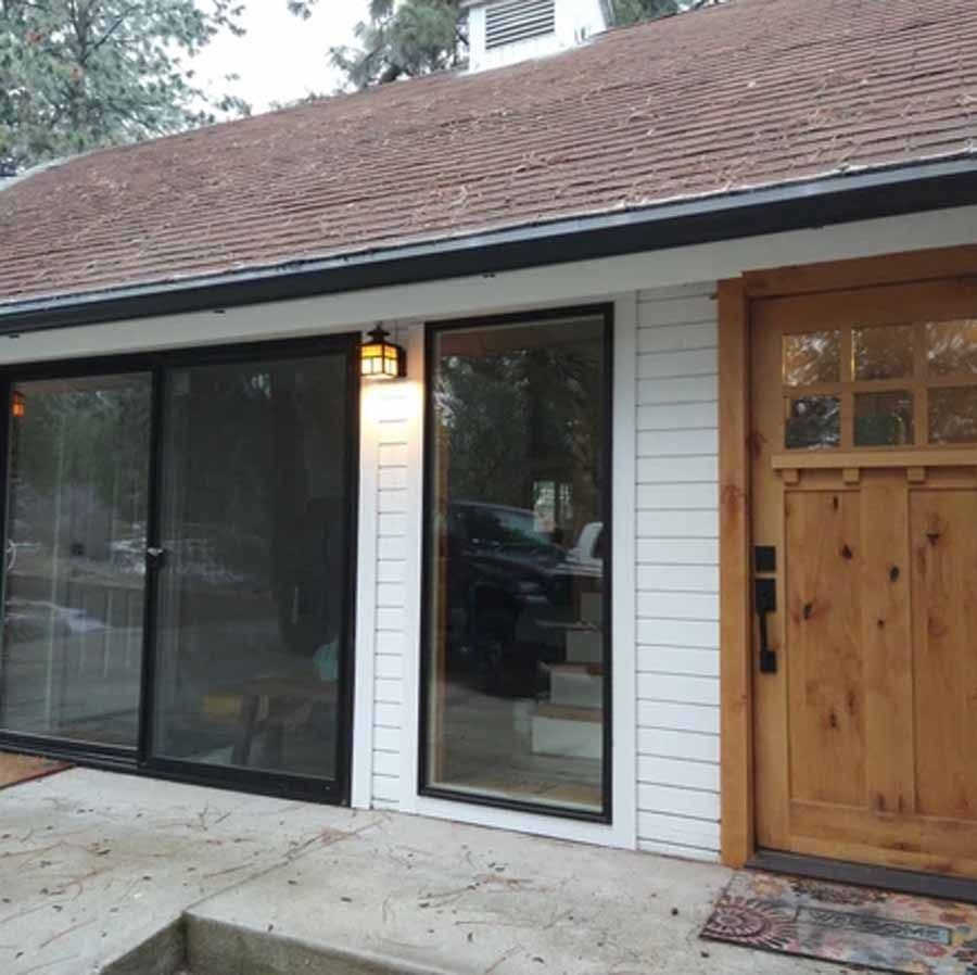 A white house with a wooden door and sliding glass doors