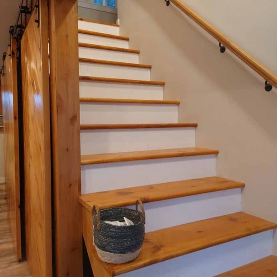 A wooden staircase with a basket on the steps