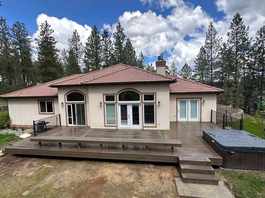 A large house with a large deck and a hot tub