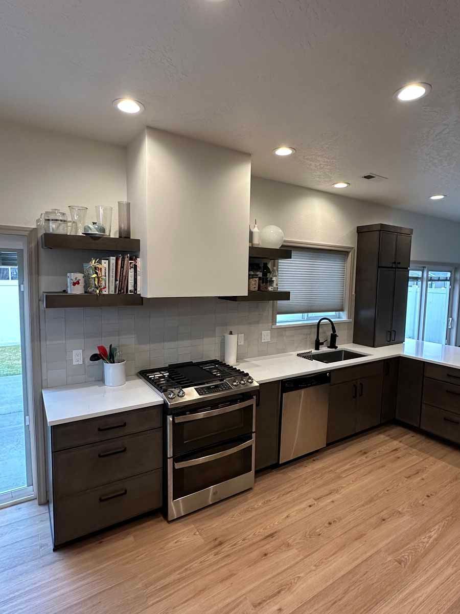A kitchen with stainless steel appliances and wooden floors.
