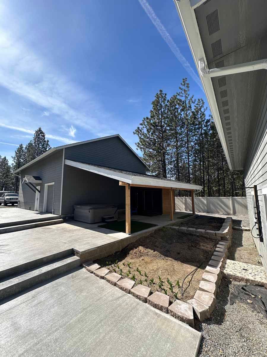 A house with a covered porch and a pool in front of it.