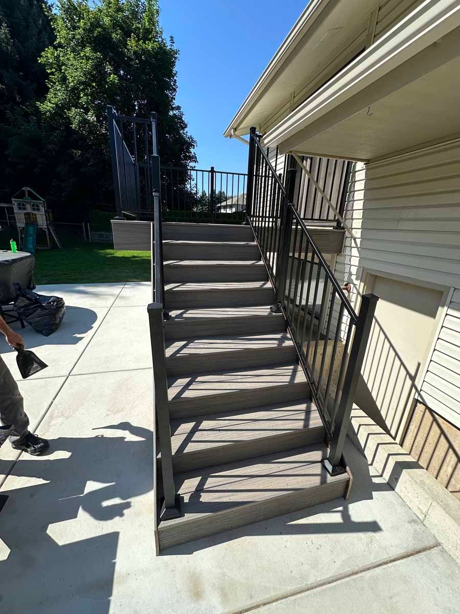 A man is standing next to a set of stairs leading up to a house.