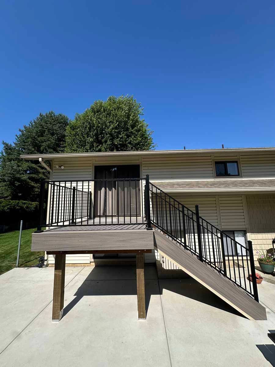 A house with a deck and stairs leading up to it.