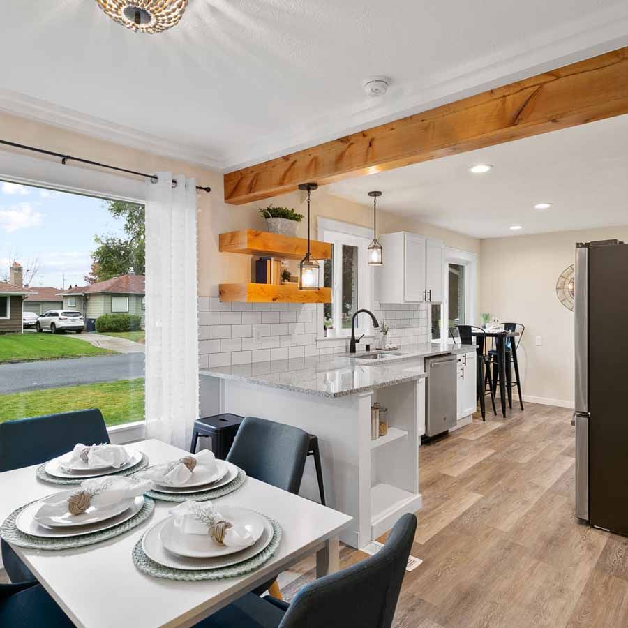 A kitchen with a table and chairs and plates on it.