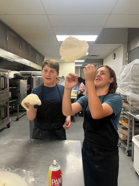 a group of children are posing for a picture while sitting around a table