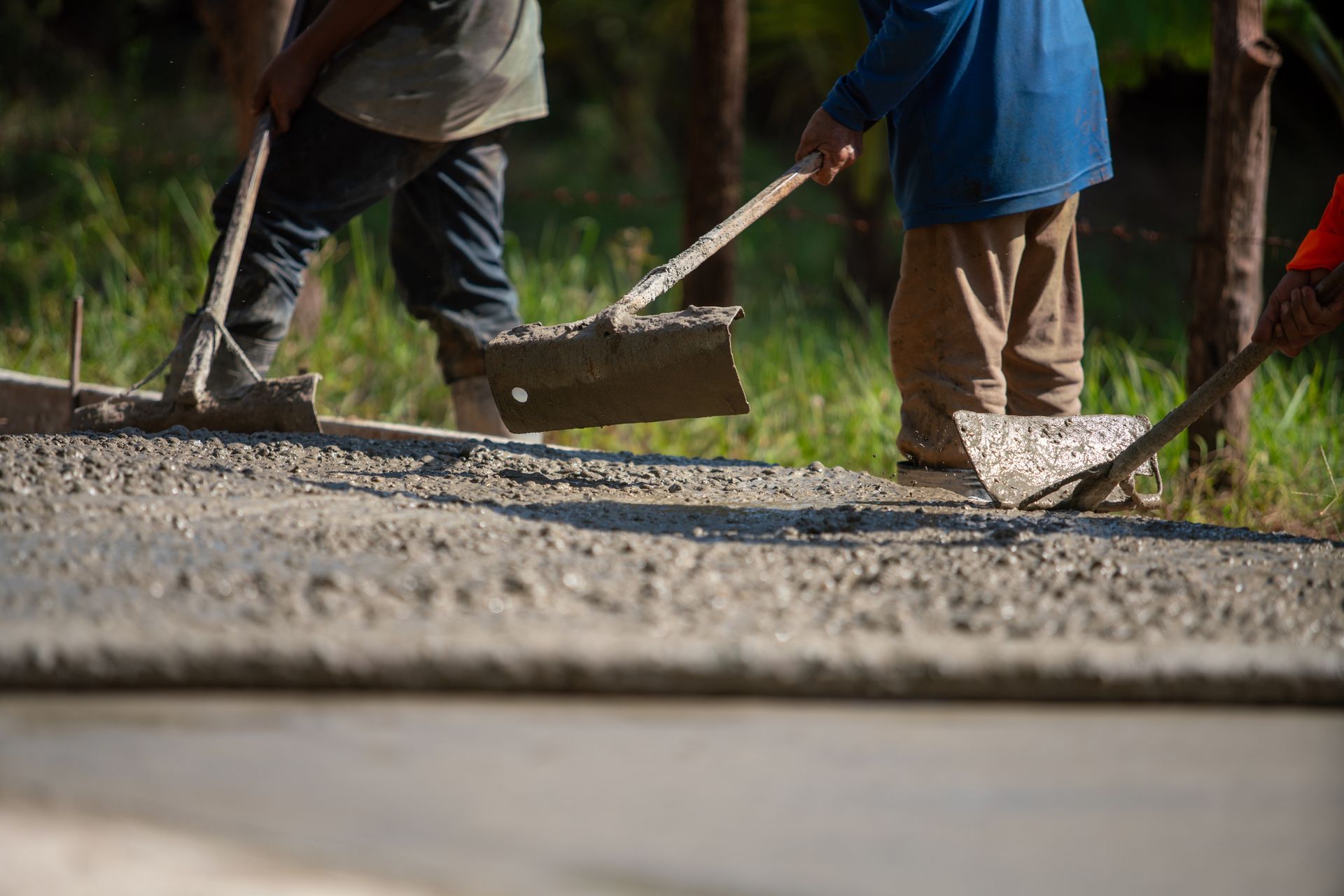 Asphalt drive Workers are using tools to level concrete in construction work.