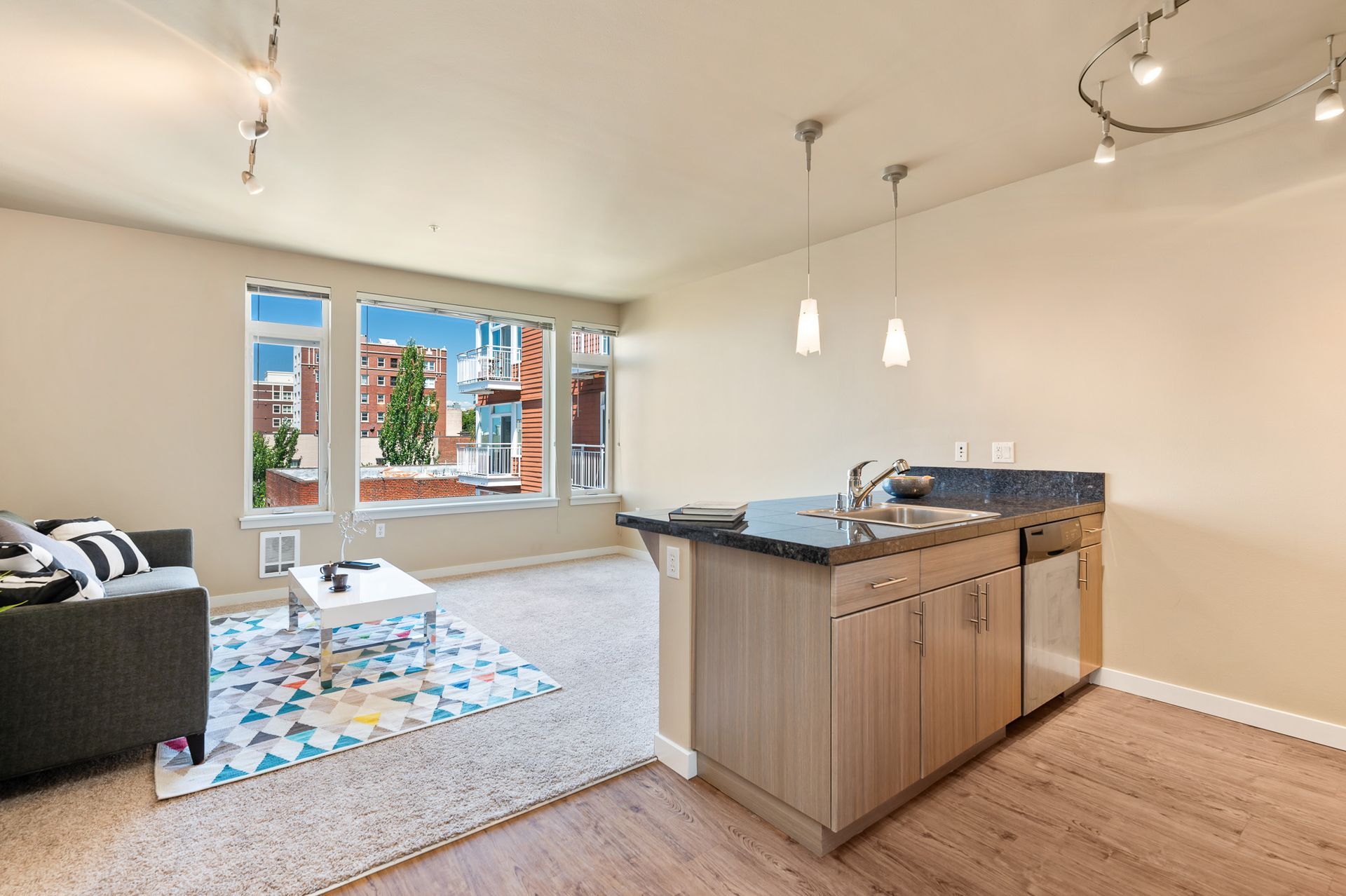 Photo of a living room, featuring the kitchen in the foregroun