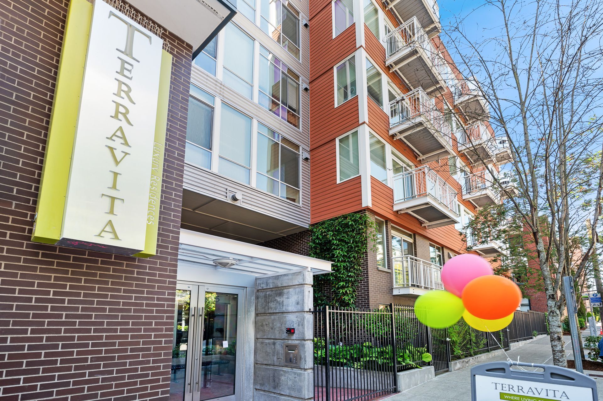 Photo of the building entrance, featuring a couple of signs that say the name of the building