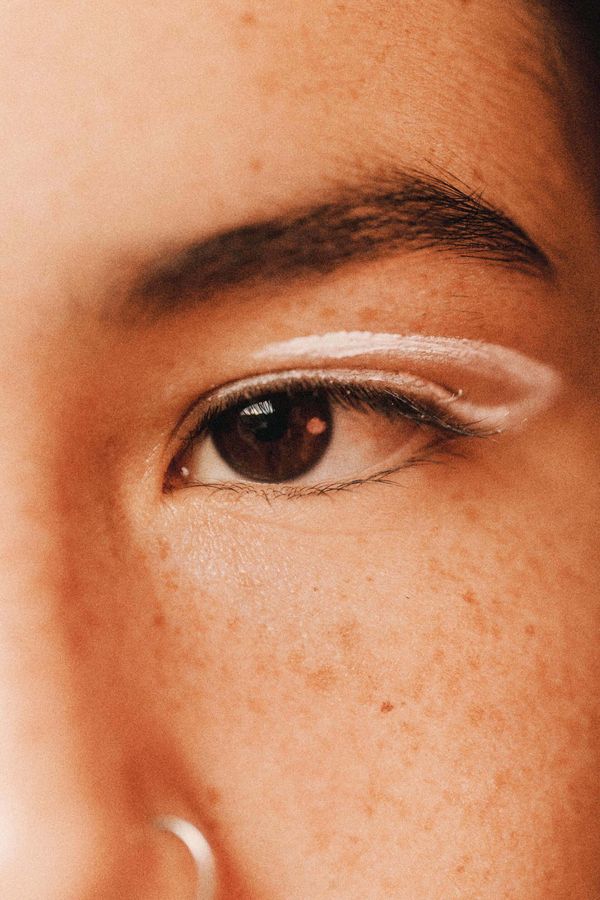 a close up of a woman 's eye with white eyeliner