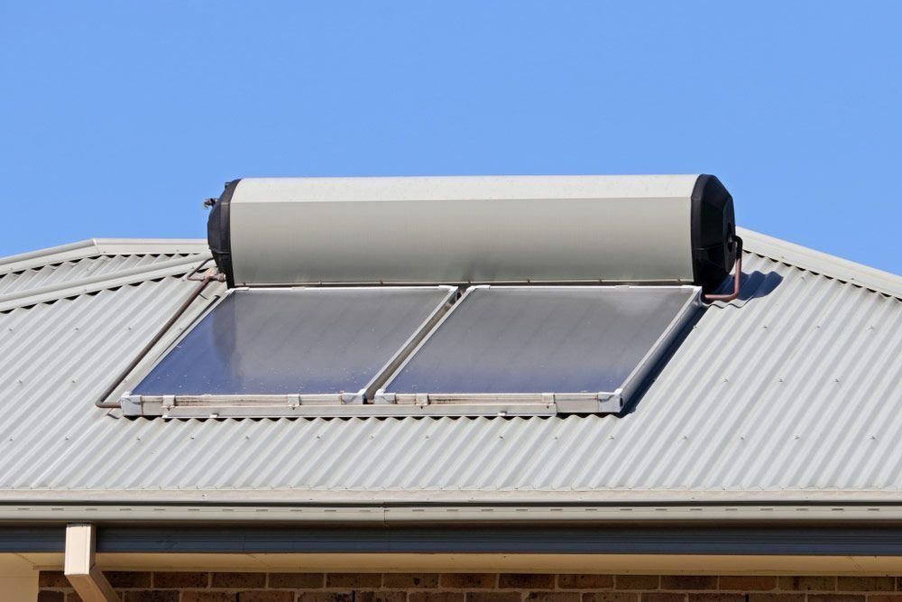 A solar water heater is mounted on the roof of a house.