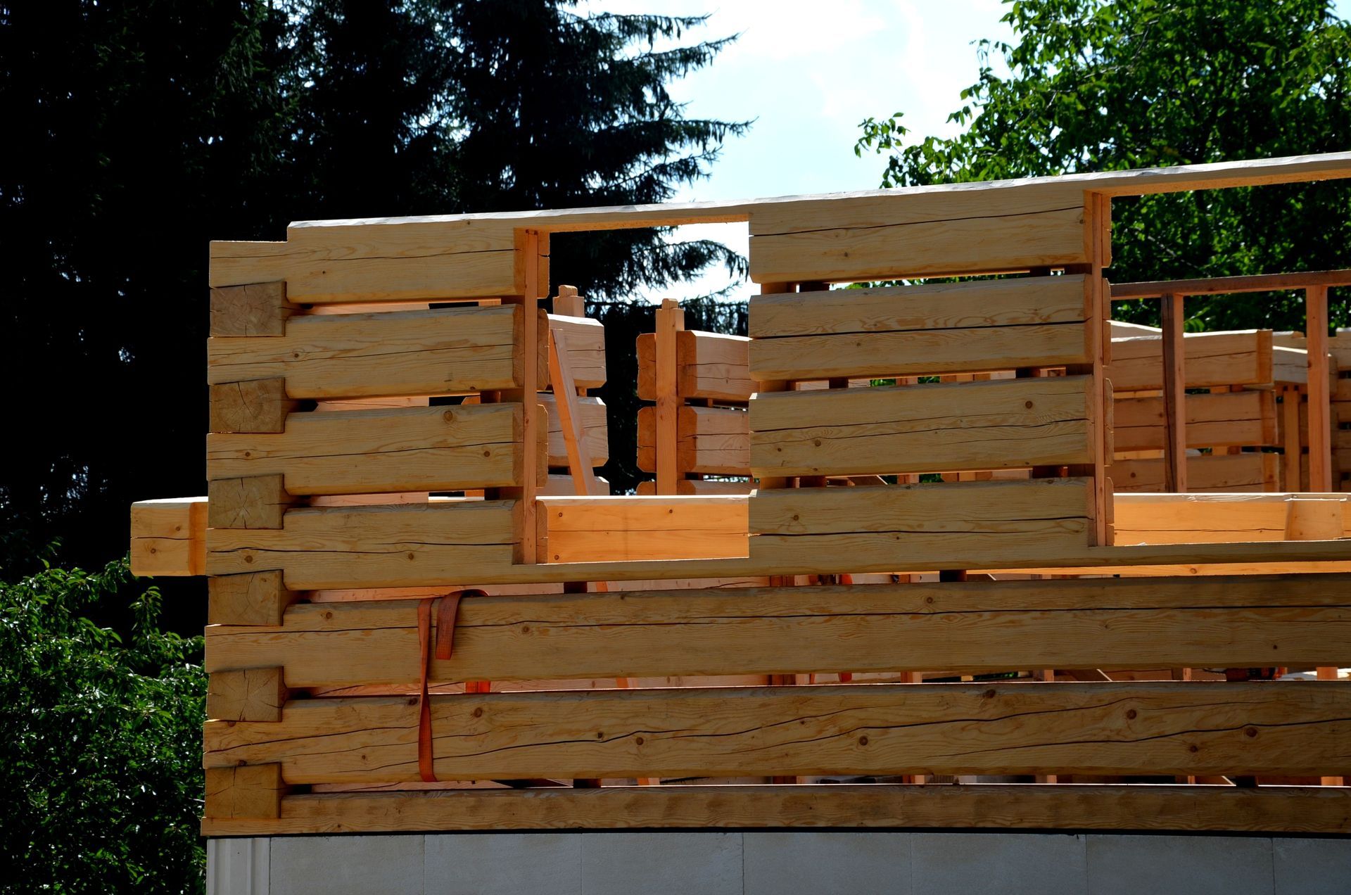 Log cabin construction with visible wooden beams and window openings.