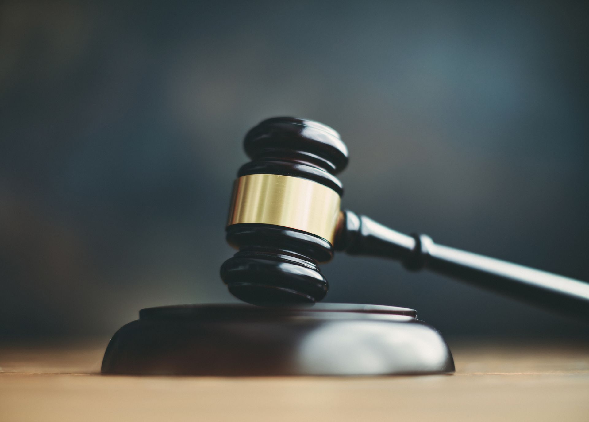 A close up of a judge 's gavel on a wooden table.