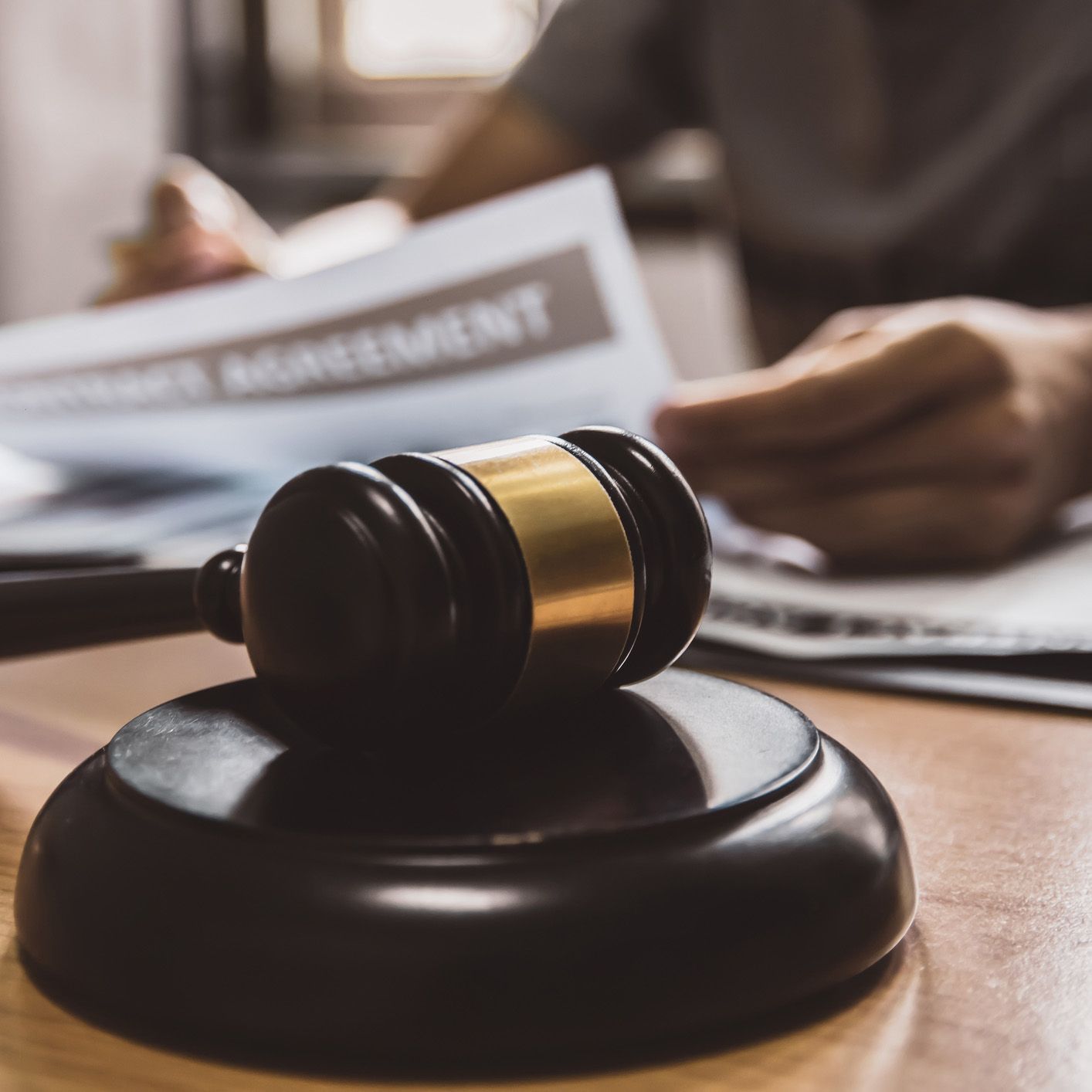 A judge 's gavel is sitting on top of a wooden table.