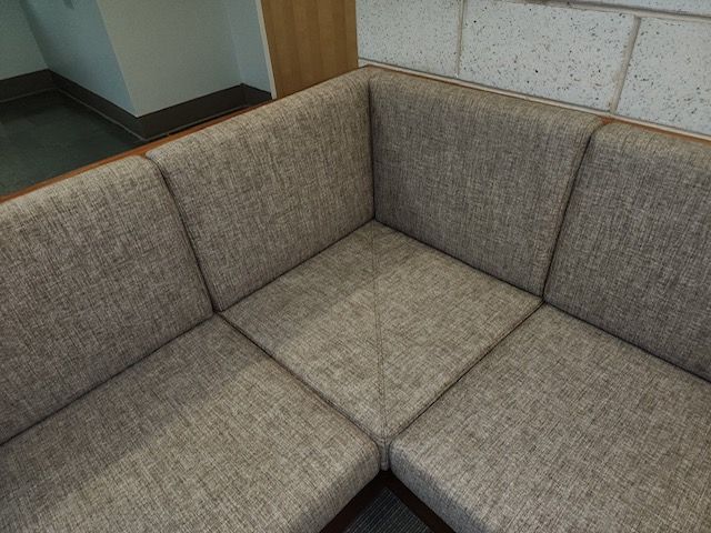 A close up of a couch in a room with a brick wall.