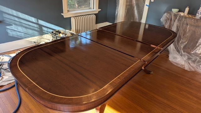 A wooden table is sitting on a wooden floor in a room.