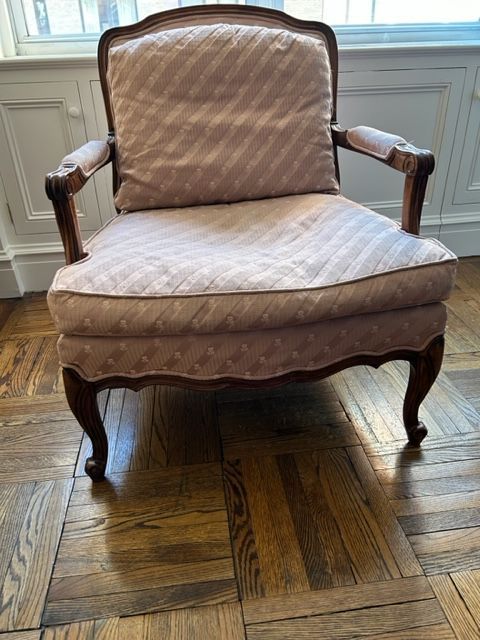 A chair is sitting on a wooden floor next to a window.